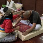 Female Shipibo Shaman treating guest at Ayahuasca retreat center Peru