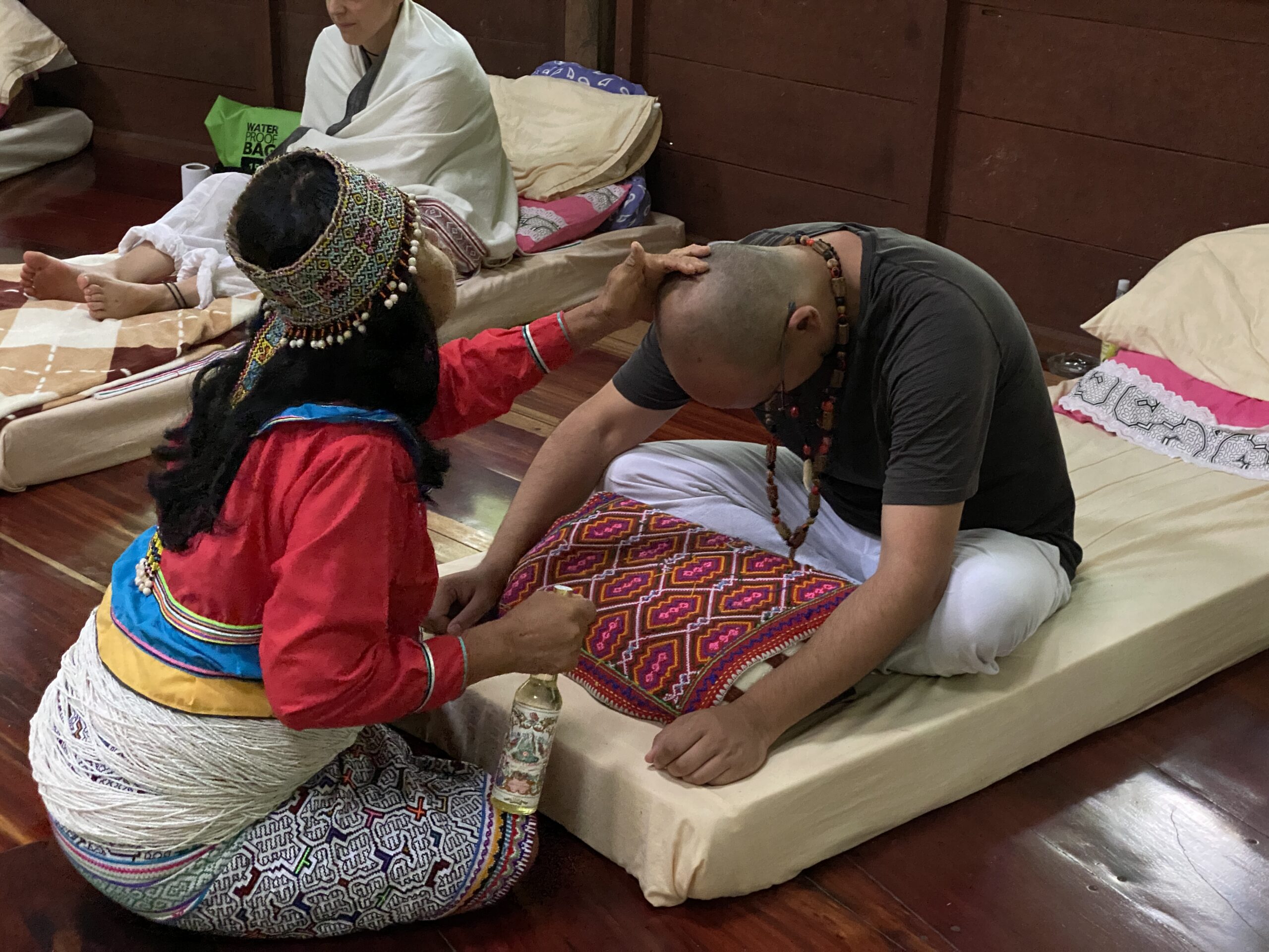Female Shipibo Shaman treating guest at Ayahuasca retreat center Peru